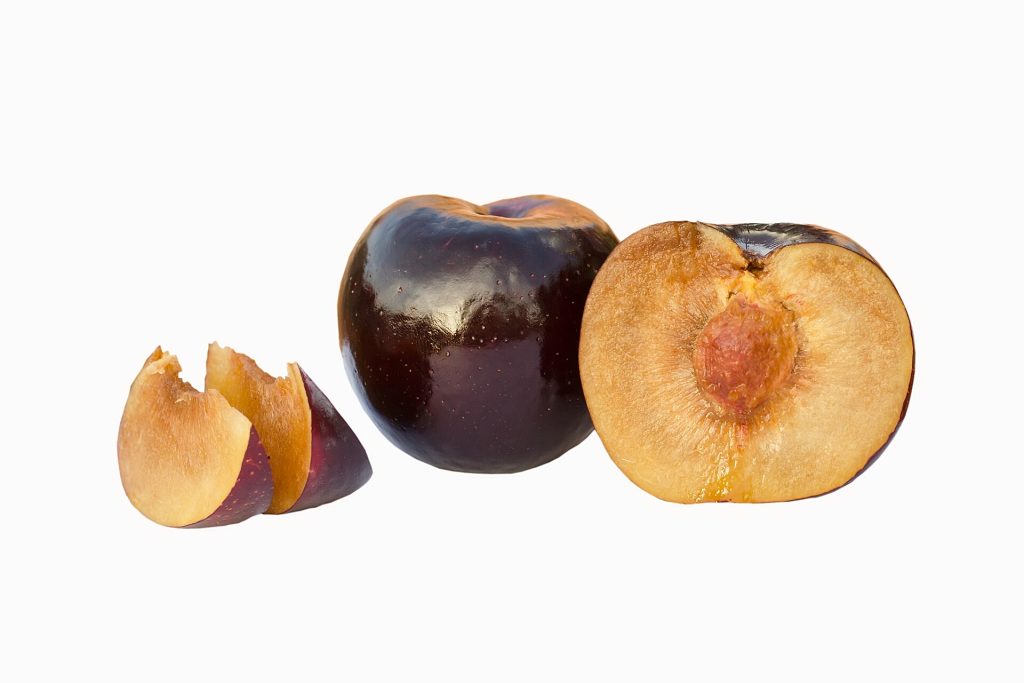 Bütün, ikiye kesilmiş ve dilimlenmiş Black Amber erikleri